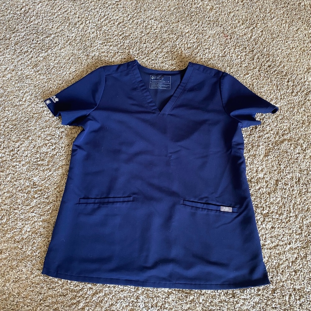 Navy Figs scrub top with Aya Healthcare logo